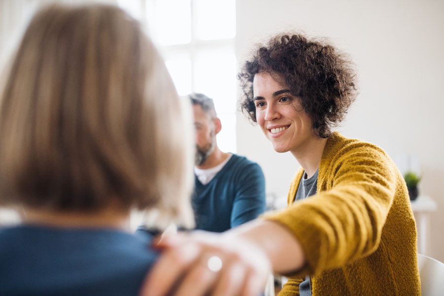 Employee Assistance Plan - Woman Comforting a Fellow Member in Group Therapy